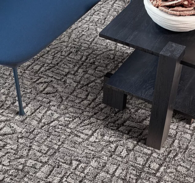 Interface E610 carpet tile in lobby with blue bench and dark wood table